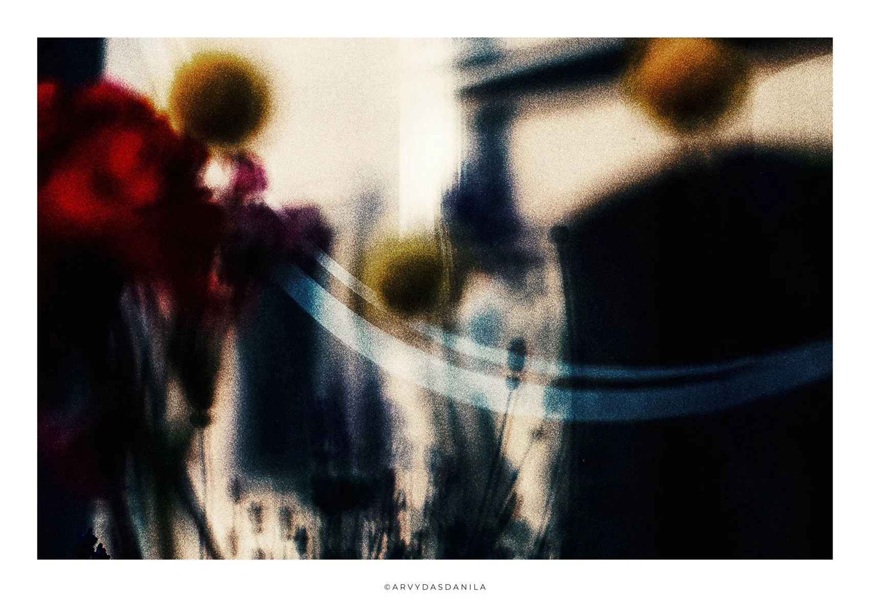 Blurred abstract image with dark shadows and bright highlights, featuring some spherical and floral shapes.