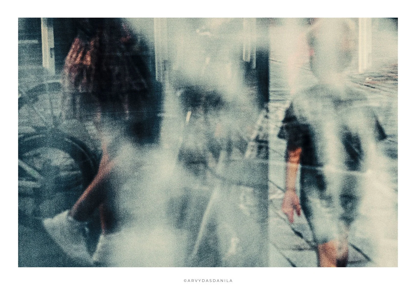 Obscured unique image of a person in city street, with indistinct figures and structures in the background.