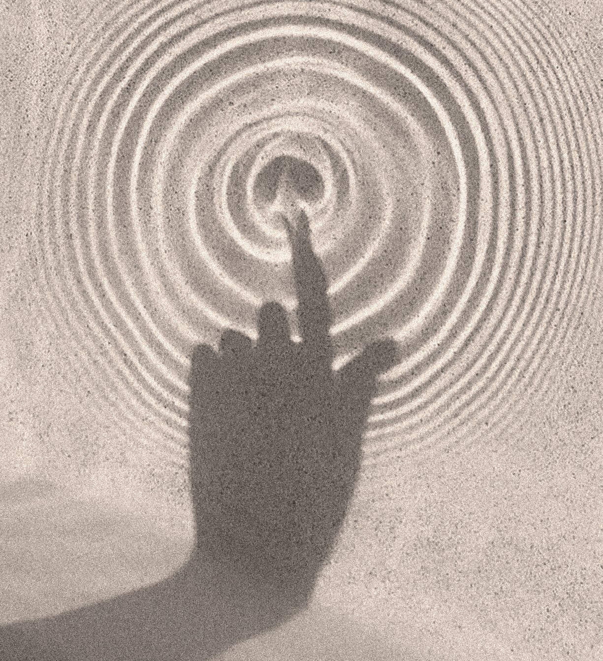 Shadow of a person's hand with index finger extended, reaching toward concentric circular light patterns on a wall.