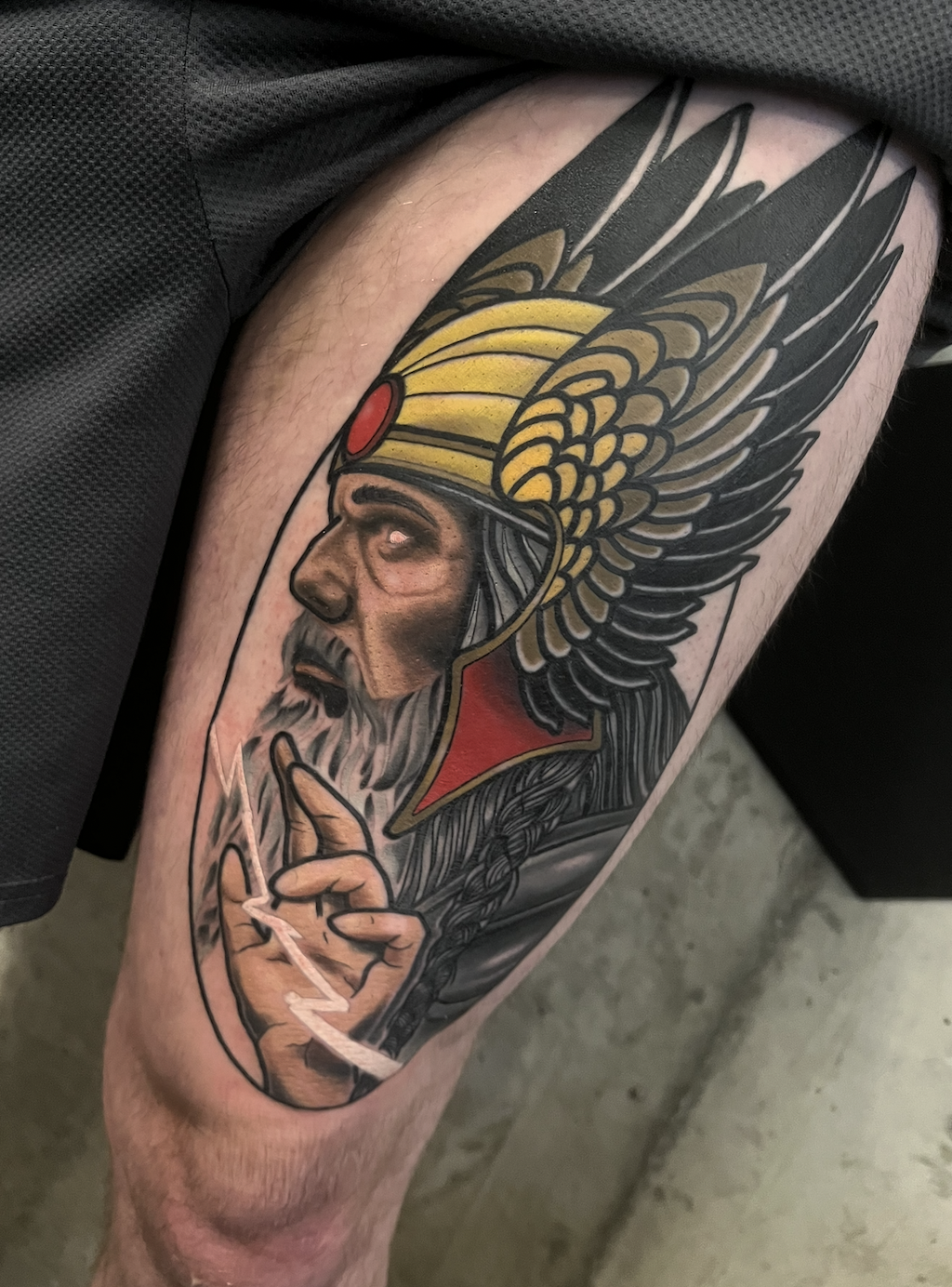 Tattoo of a Native American man wearing a feathered headdress, holding a lit peace pipe, with detailed shading and vibrant colors.
