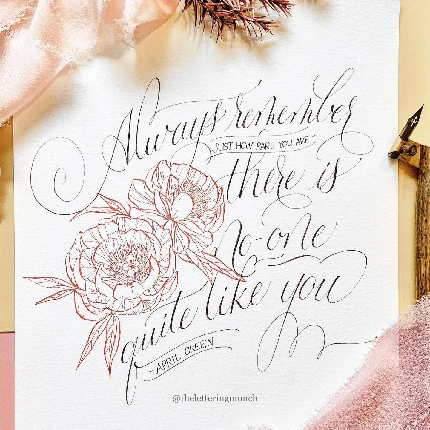 Handwritten quote with floral illustrations on textured paper, surrounded by pink fabric and dried flowers.