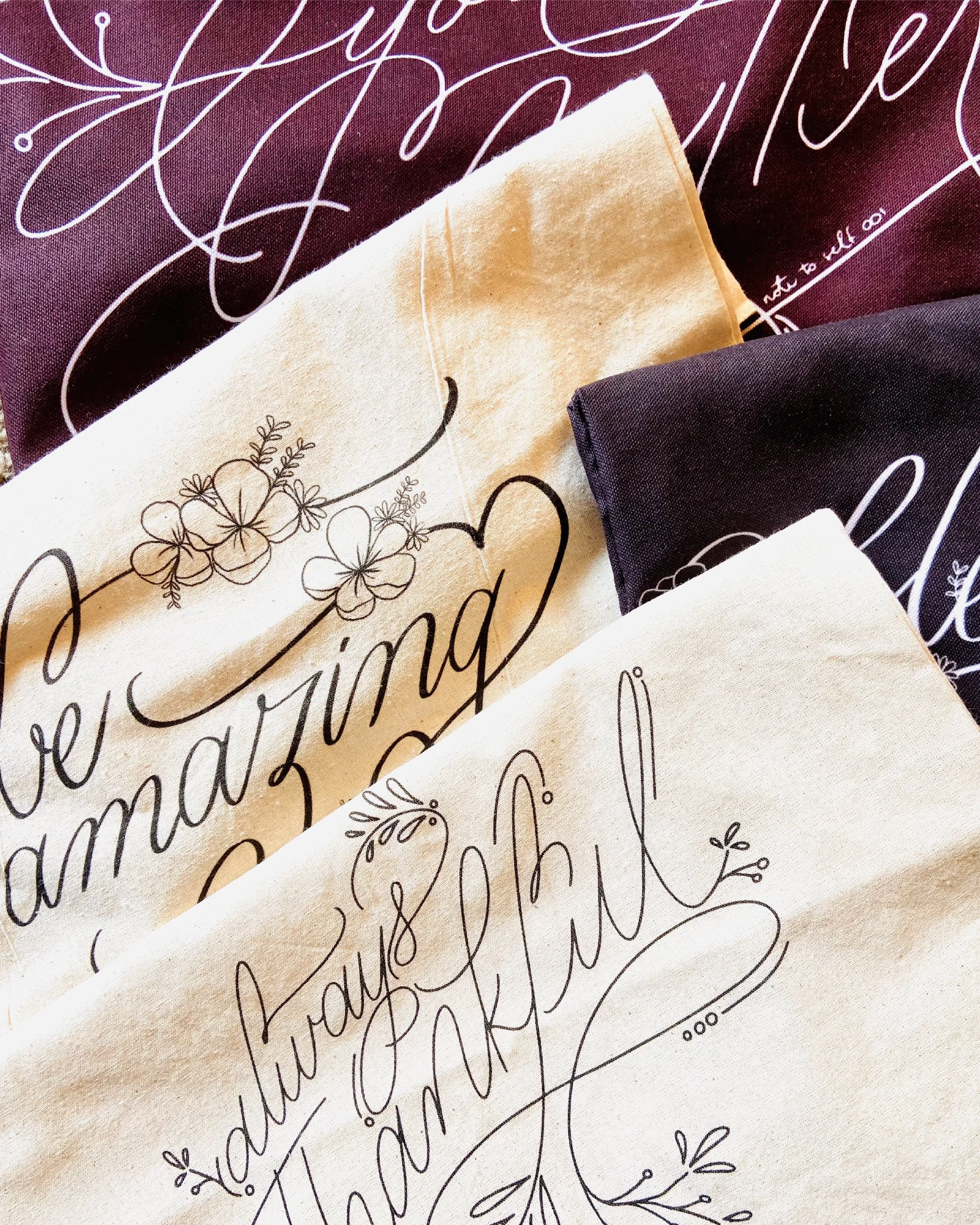 Close-up of a fabric with elegant cursive lettering and floral designs, including text and decorative elements.