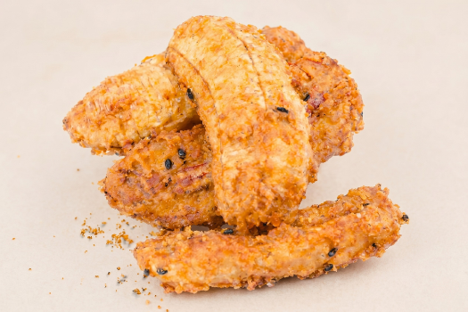 Close-up of crispy fried chicken wings on a light background.
