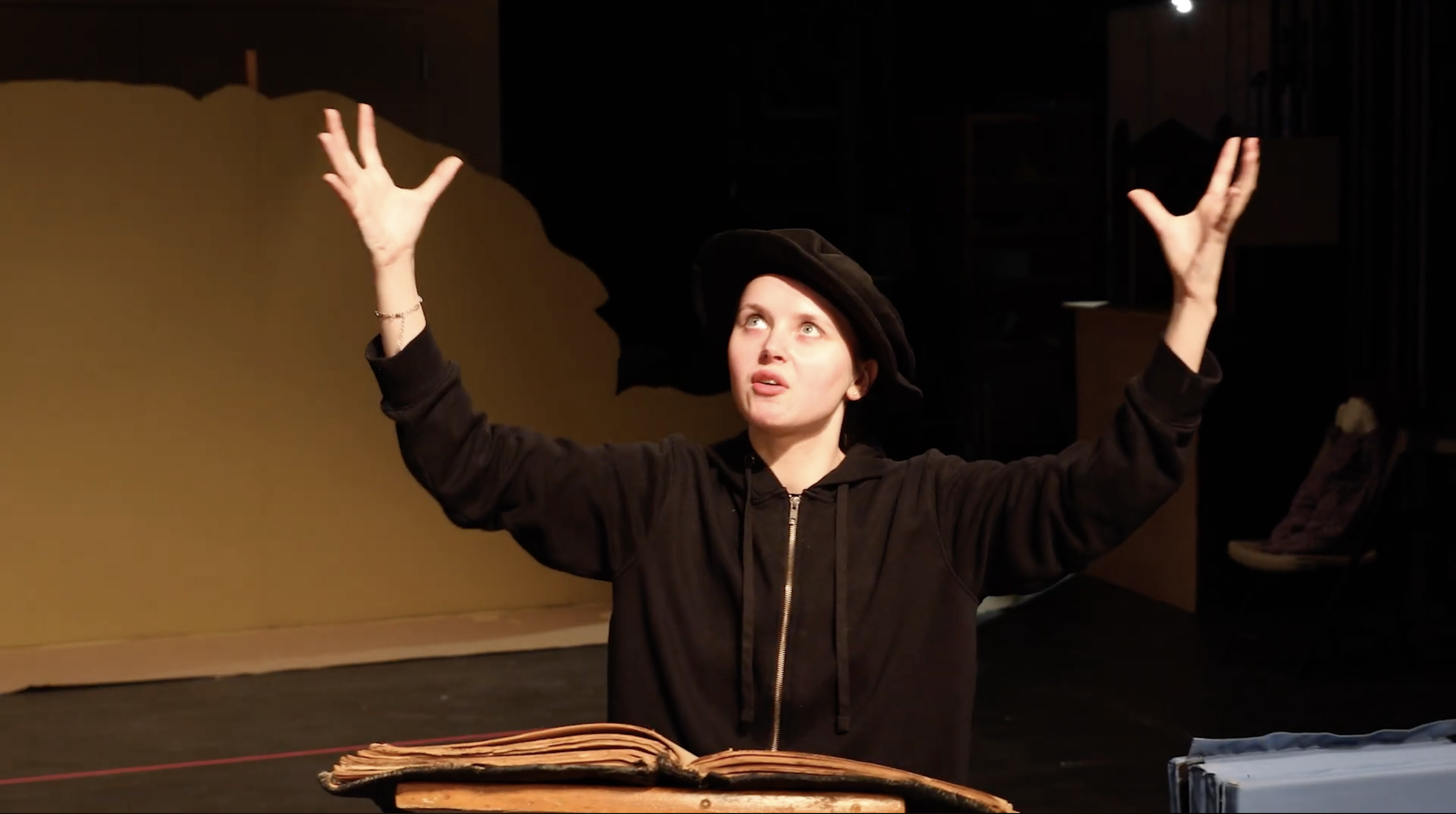 An actor holding their arm up in the air.