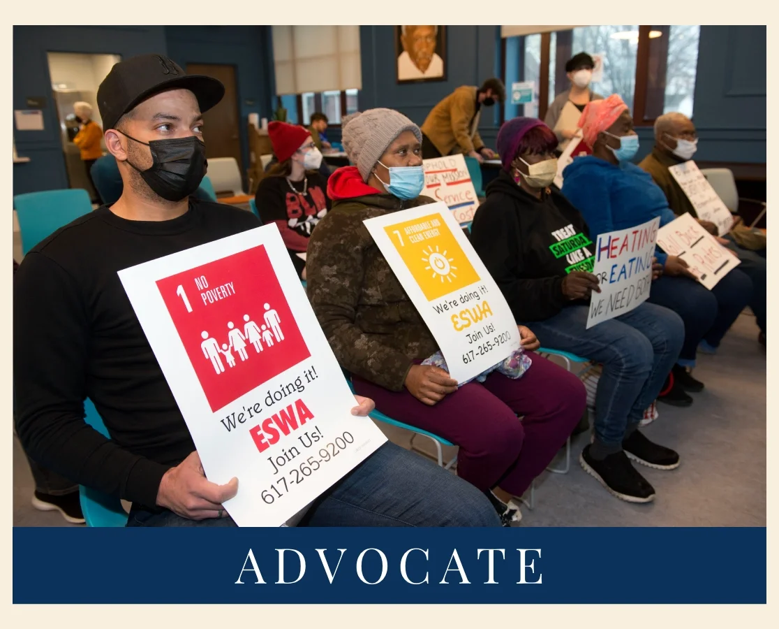 Headline of image says "ADVOCATE." Above shows a row of five seated members all holding up signs. The sign in the foreground reads, "NO POVERTY."