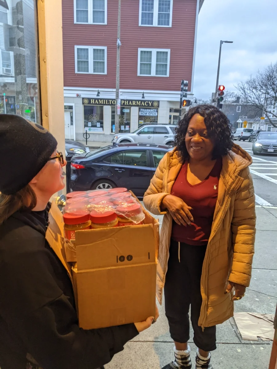 ESWA volunteer drops of a donated case of peanut butter with another ESWA volunteer.