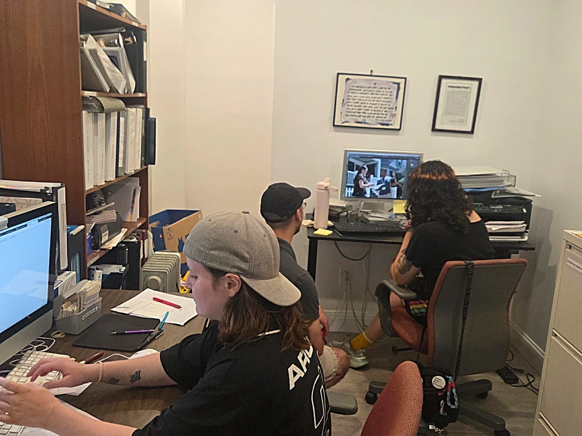 ESWA volunteers sitting at a computer editing photos.