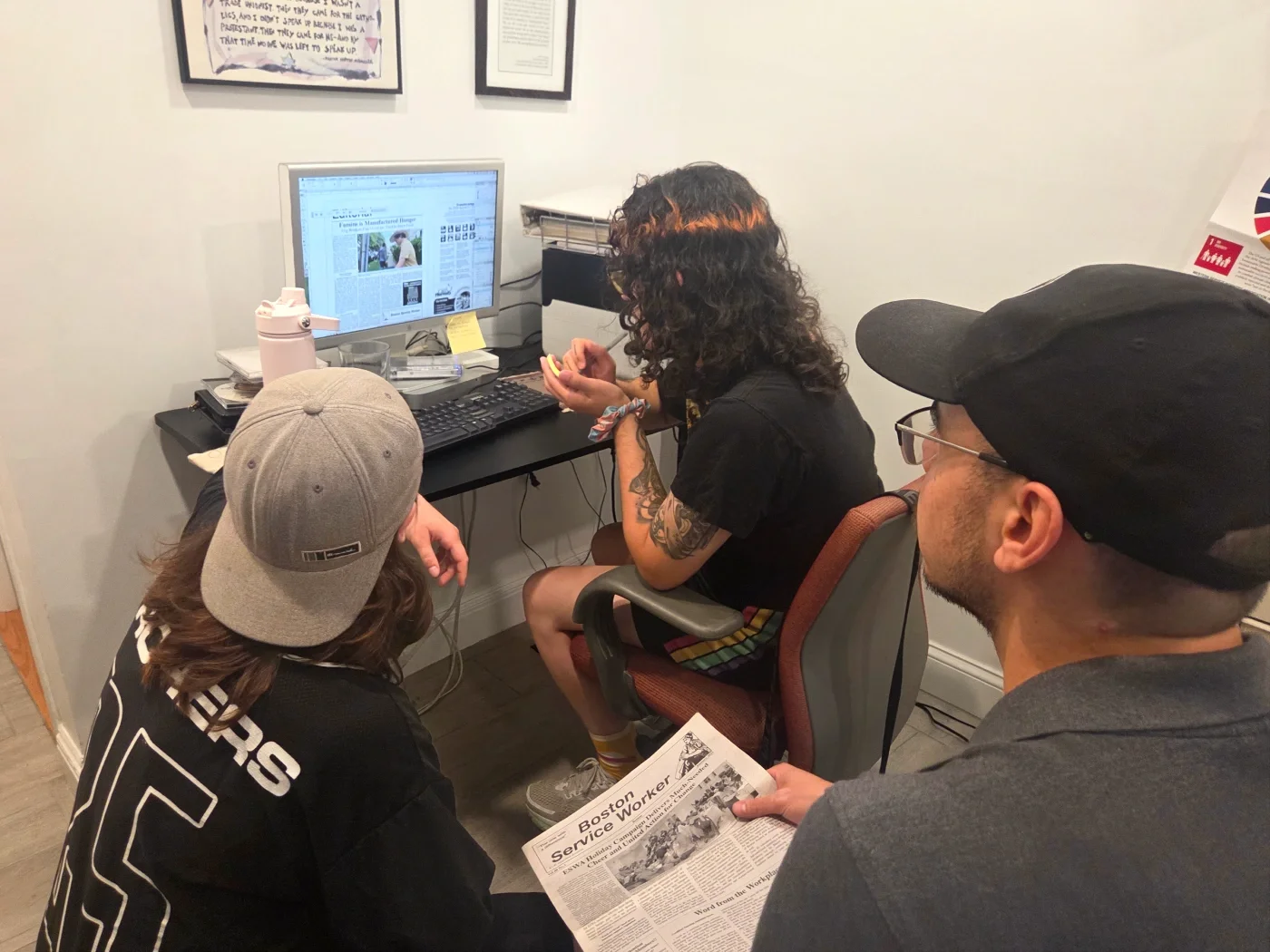 Photo of volunteers at a computer designing the layout for the BSW.