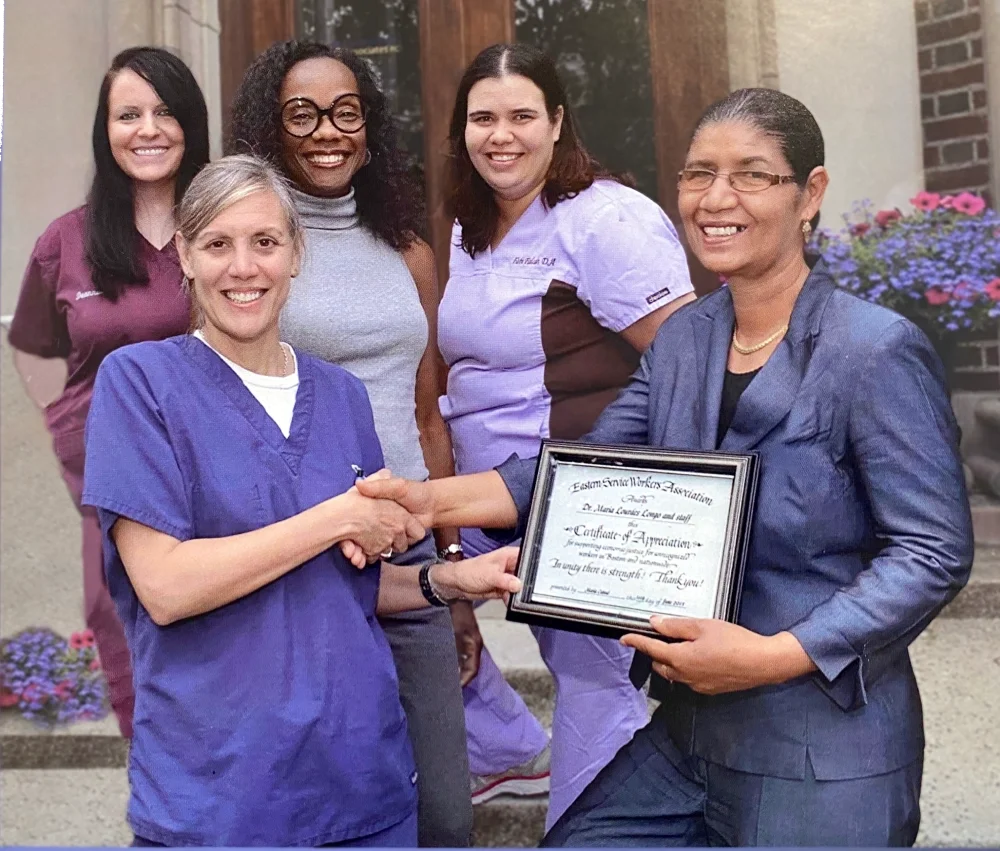 ESWA volunteer presents a certificate of appreciation to a volunteer dentist and her staff.