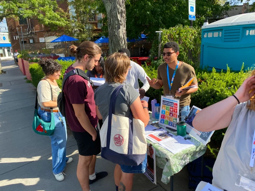 ESWA organizer speaking to two people at a literature table.