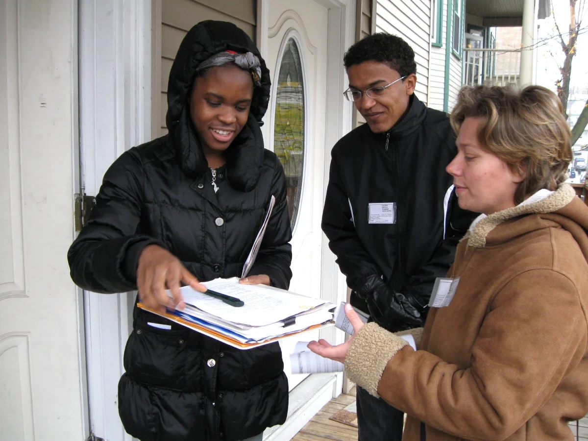 ESWA volunteers signing up a new member, all wearing winter coats.