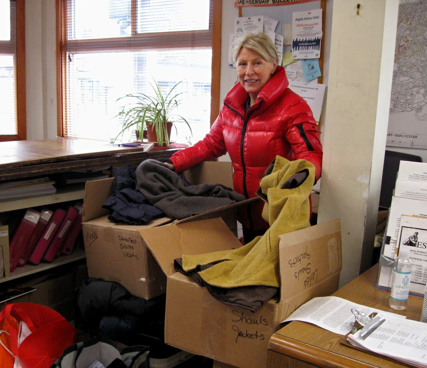 ESWA supporter holds up donated winter coats.