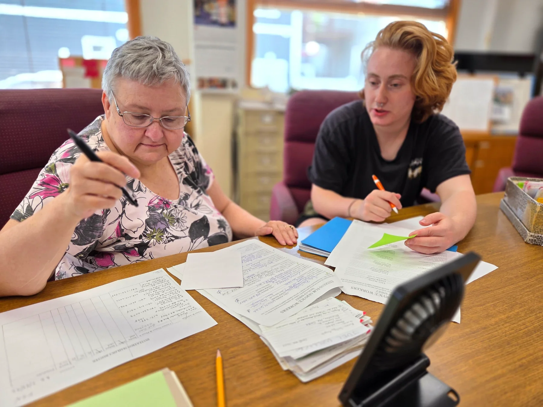 ESWA organizer briefs a volunteer on contacts to mail letters to.