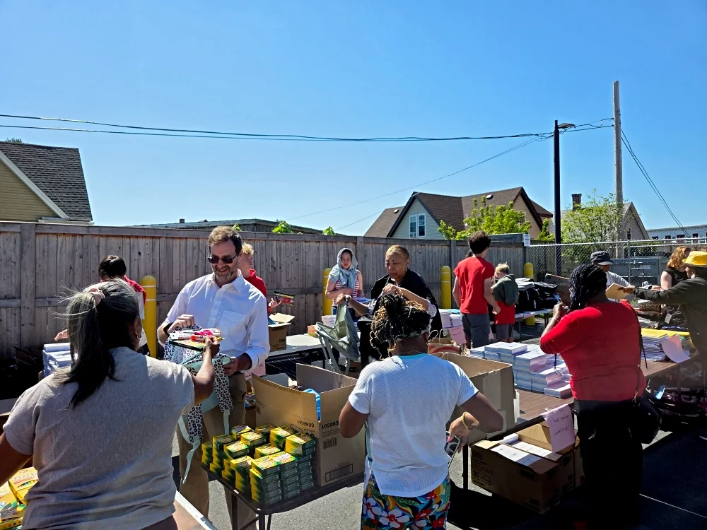 Photo of volunteers at an outdoor distribution of back-to-school supplies.