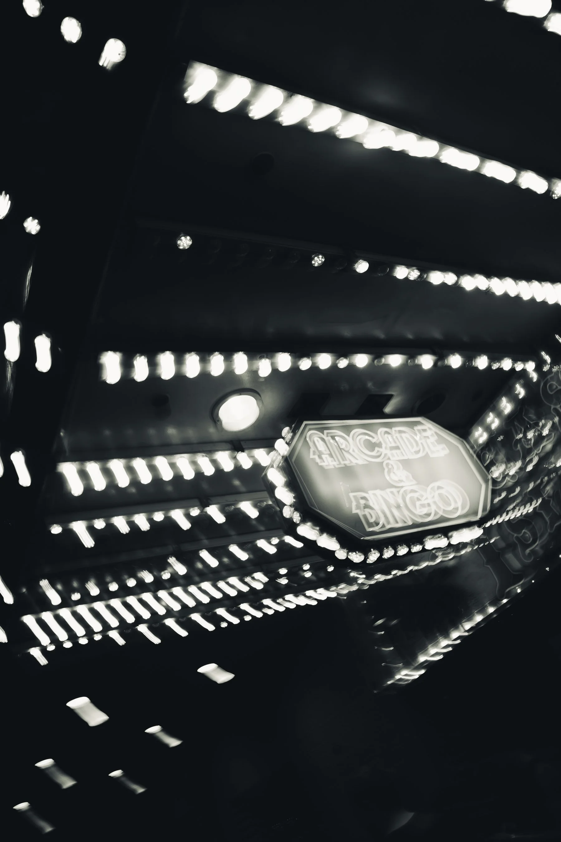 Brightly lit arcade game with illuminated sign reading 'ARCADE'.