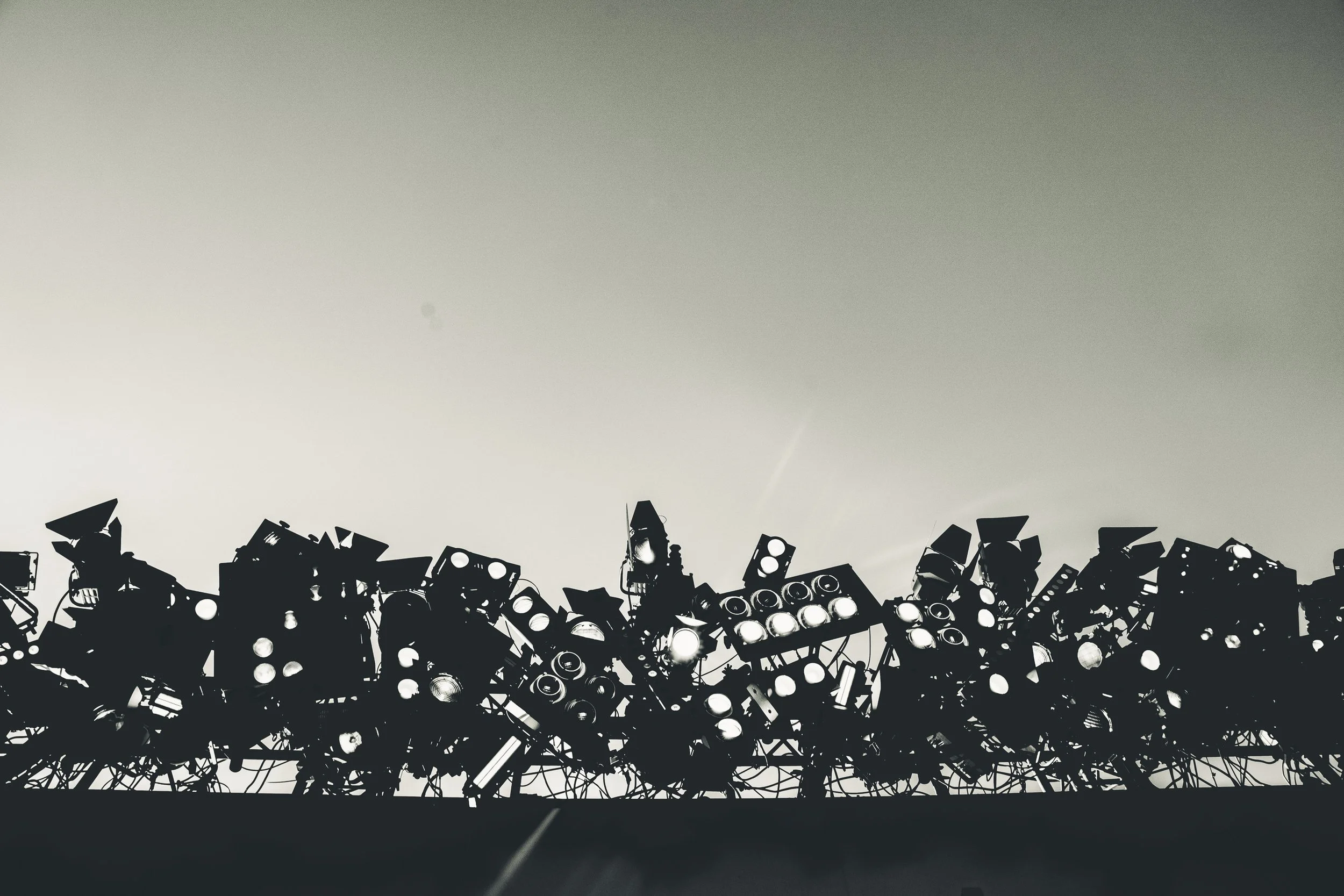 Stage lighting and equipment silhouetted against a sunrise or sunset.