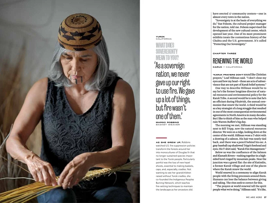 A woman with gray hair, wearing a black top and a hat, is sitting and working with basketry materials.