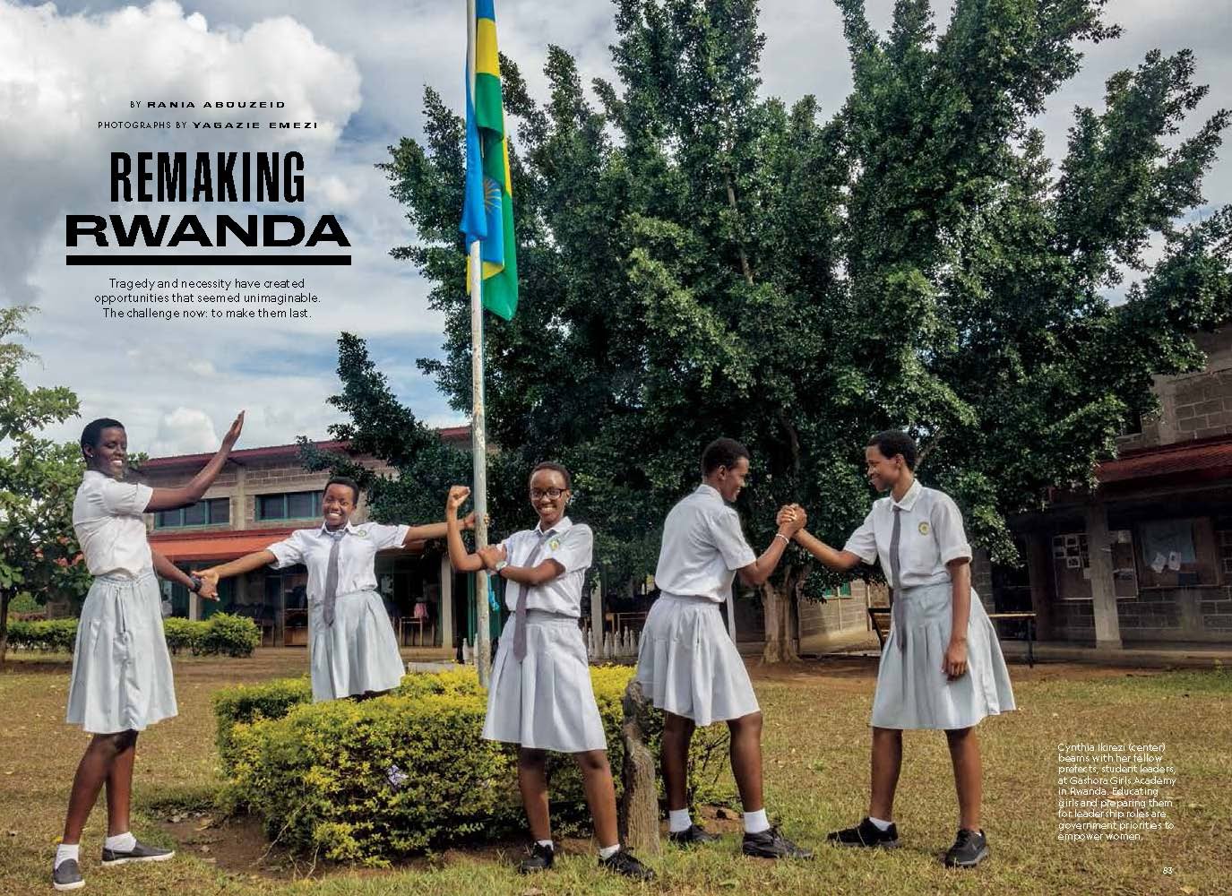 Five schoolgirls in white uniforms are standing outside near a flagpole with the Rwandan flag, smiling and holding hands, with a large tree and school building in the background and a headline "Remaking Rwanda"