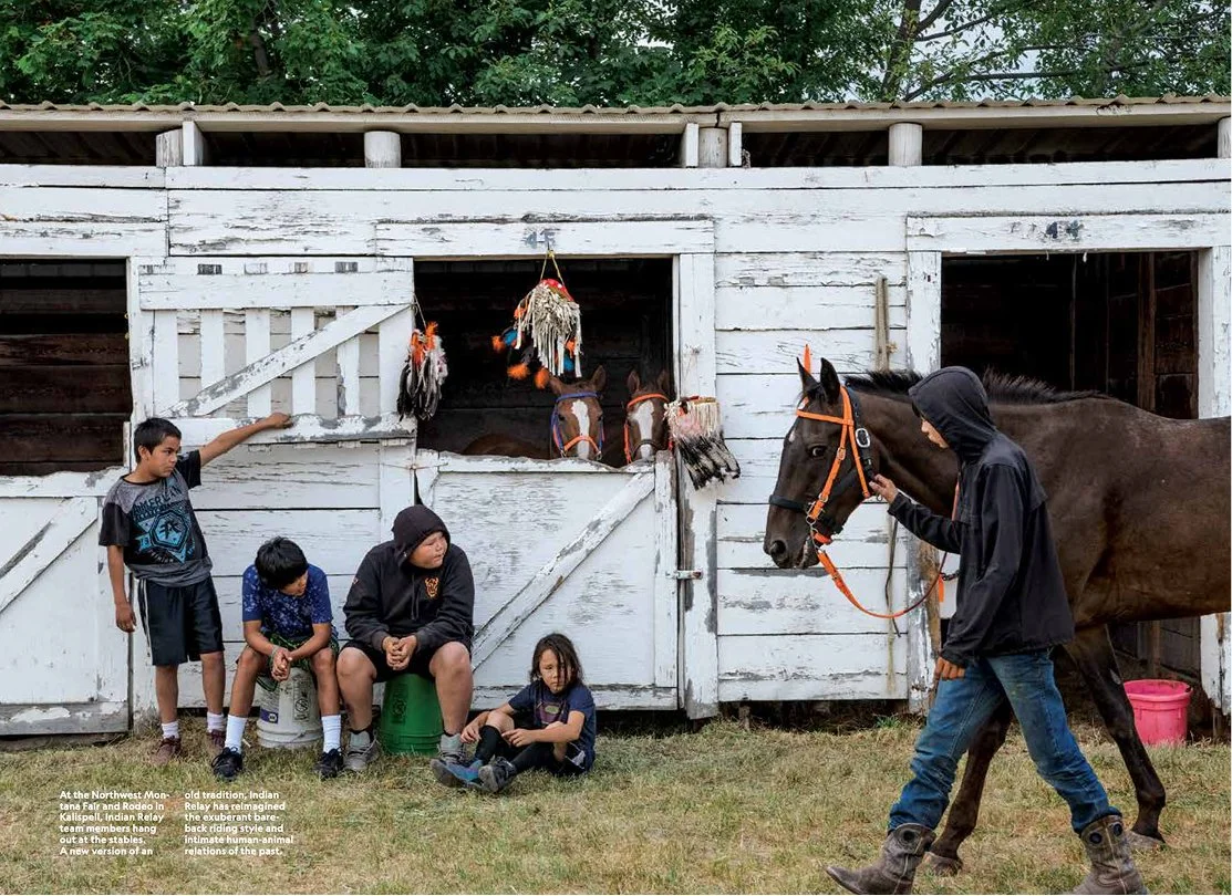 Children and a young man with a horse outside a stable