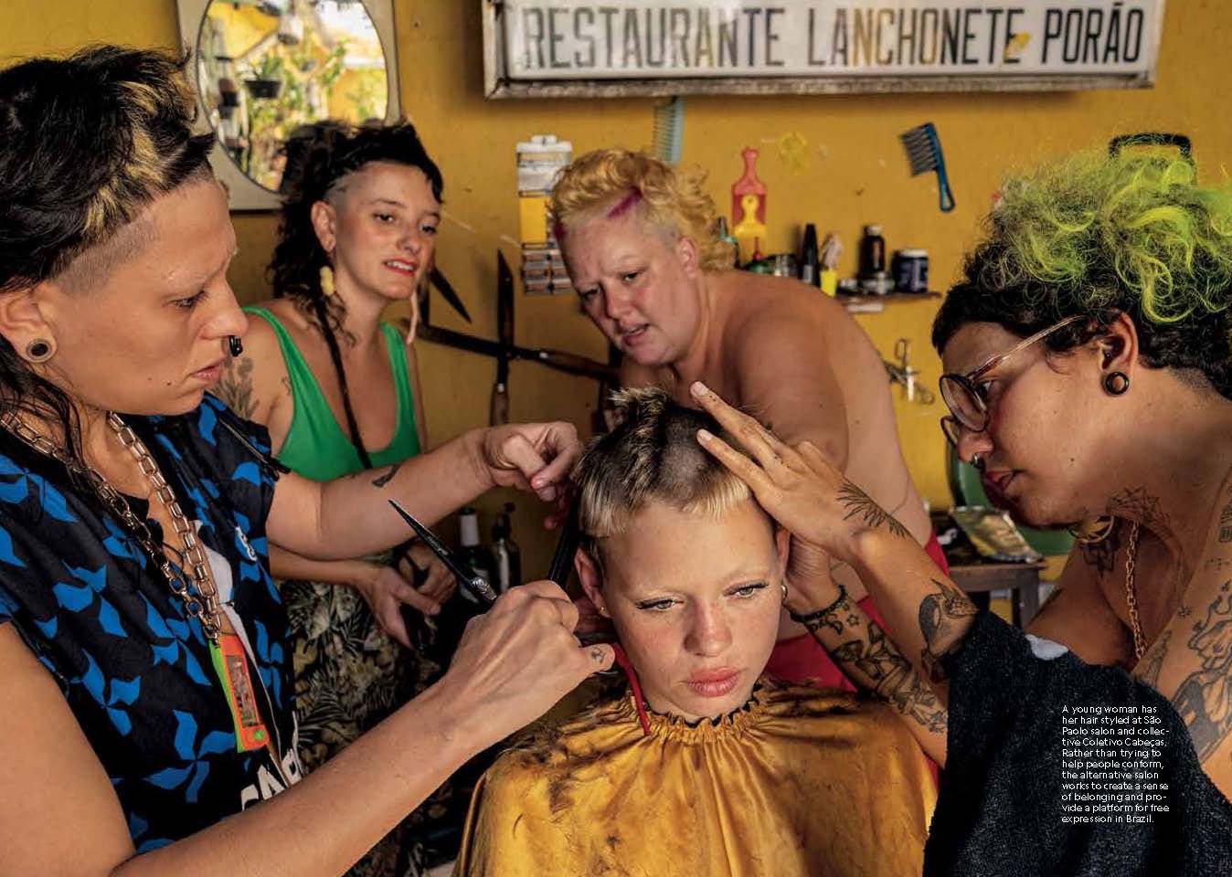 A young person having their hair done in a salon by four other people.