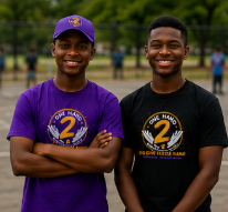 Two young men wearing purple and black shirts with number 2 graphics, standing outdoors on a track field, smiling.