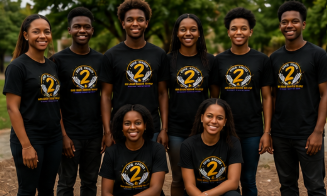 Group of seven young people outdoors, wearing matching black T-shirts with yellow and white graphics, smiling for a group photo.