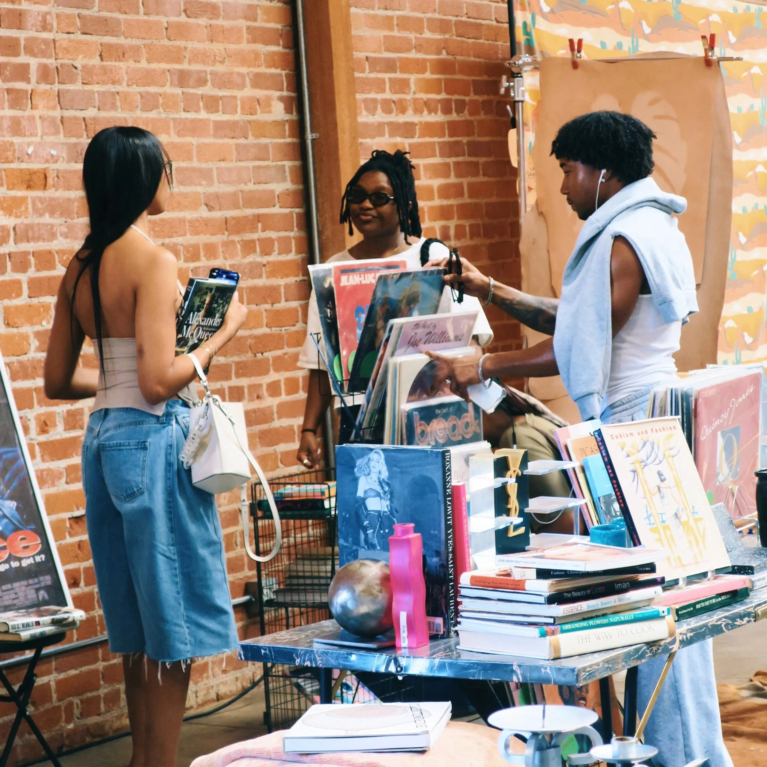 Friends in conversation amongst literature and vinyls