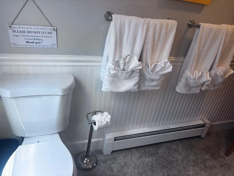 Clean toilet area with neatly arranged towels prepared for Airbnb guests.
