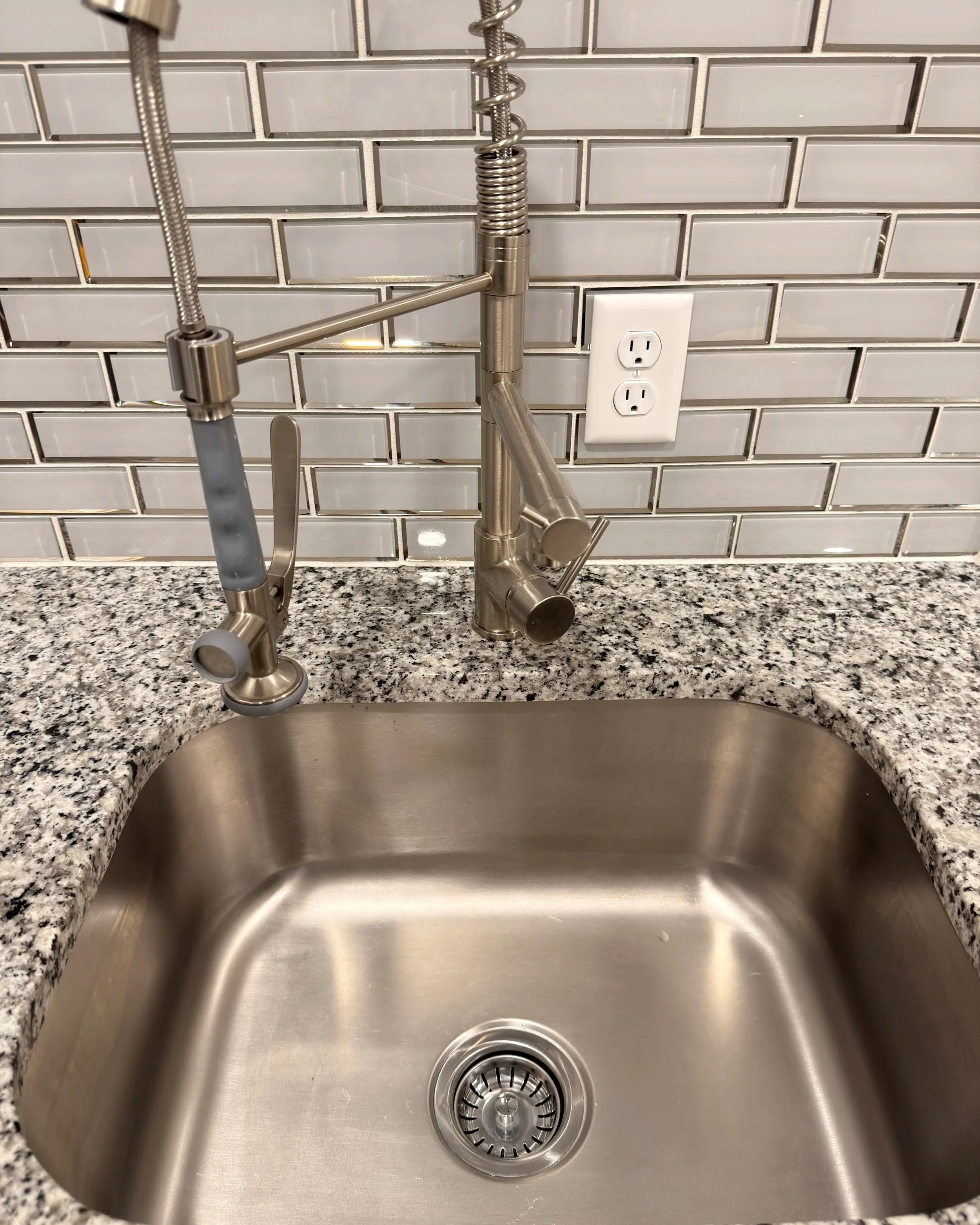 Clean kitchen sink and countertop after a standard residential cleaning.