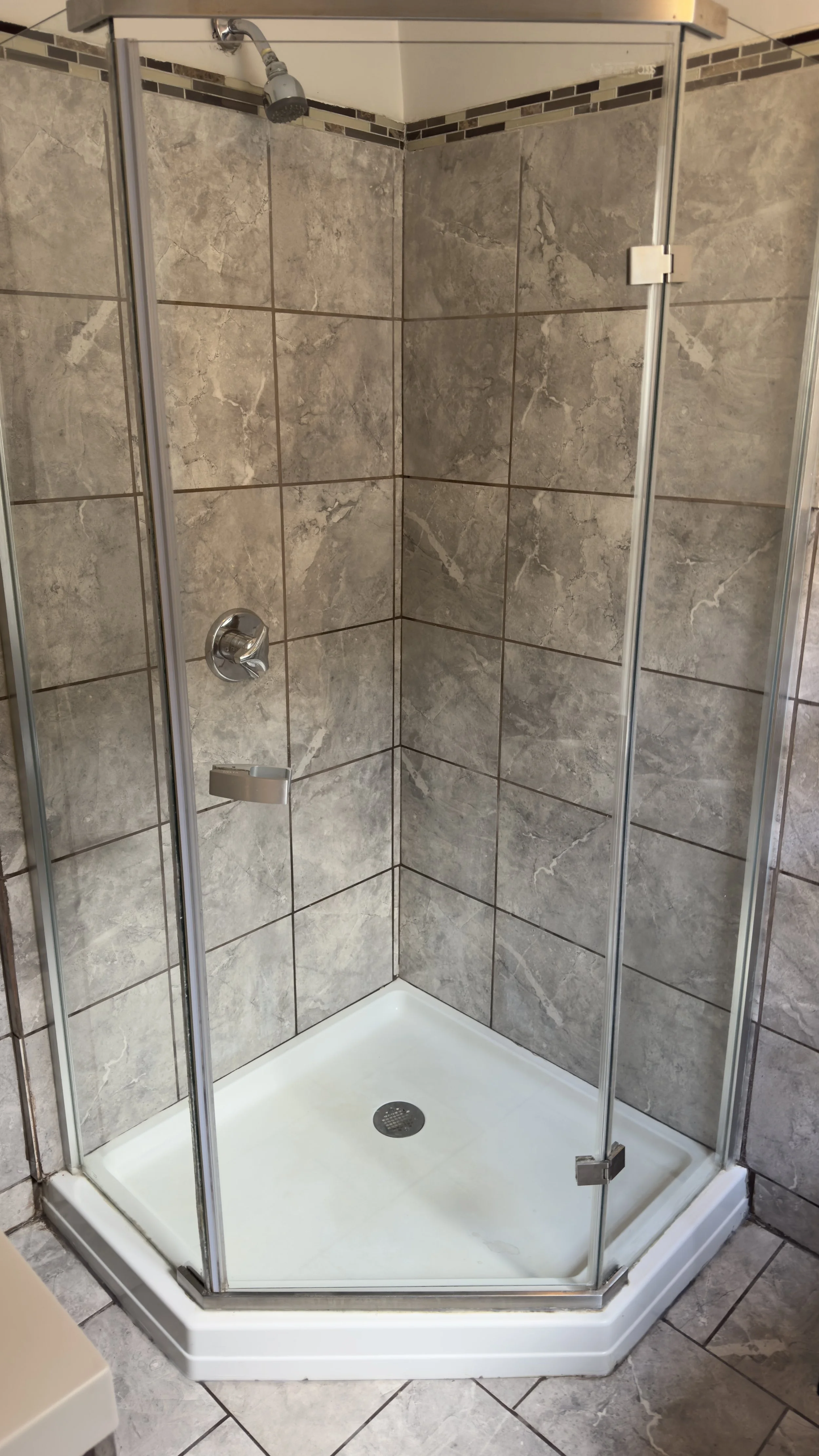 Spotless glass shower enclosure after a detailed deep cleaning.