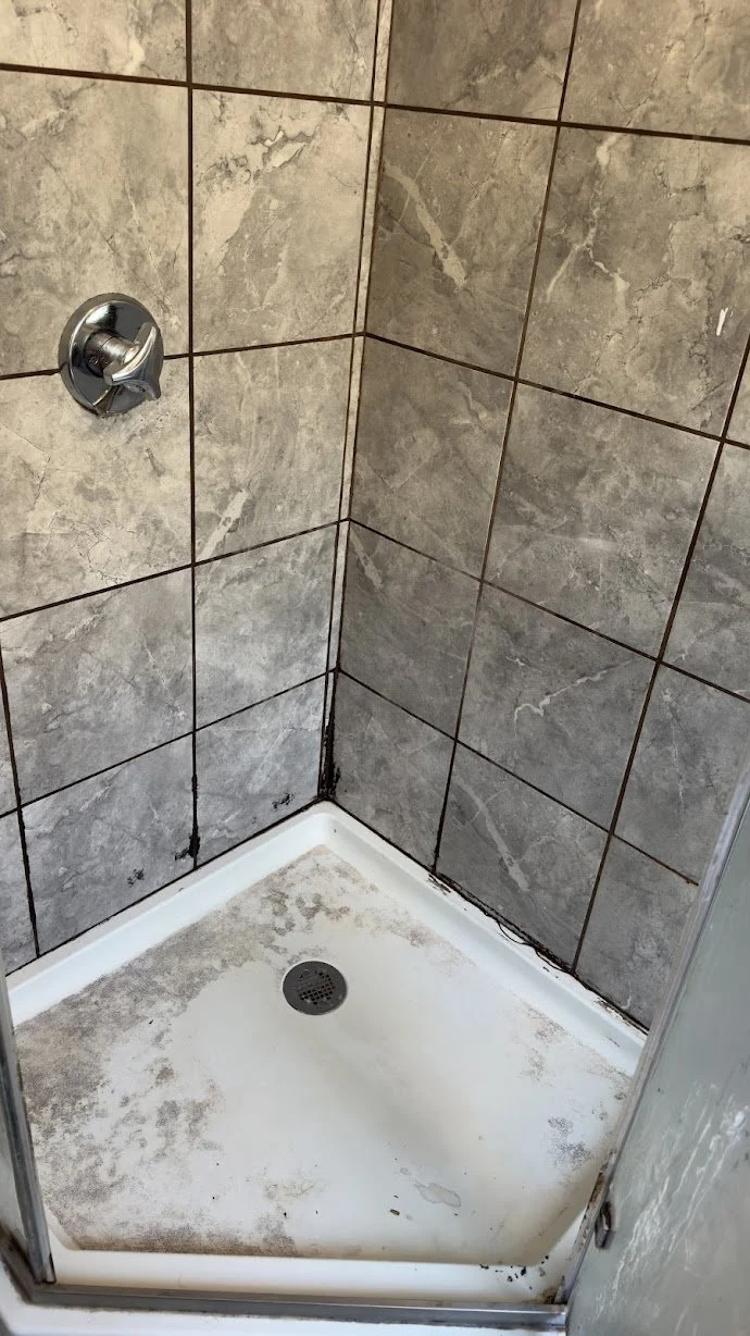 Glass shower enclosure before a detailed deep cleaning.