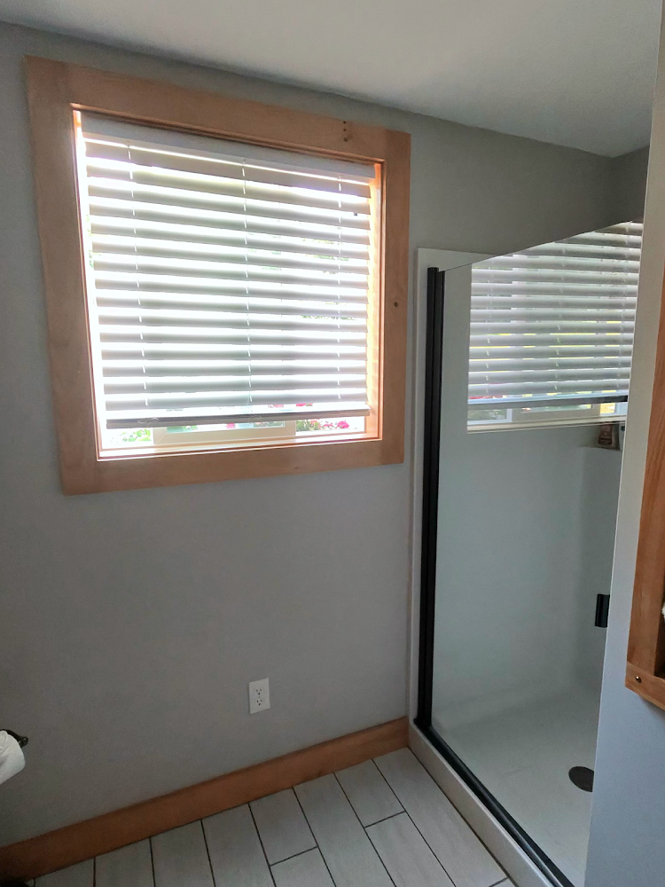 Clean bathroom with a window and glass shower prepared for Airbnb guests.