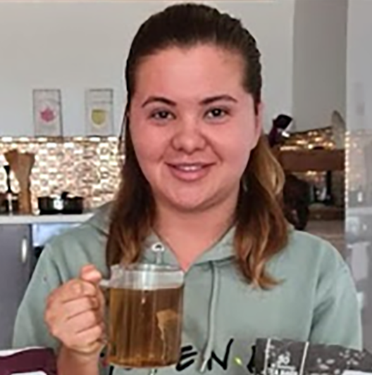 Young woman smiling and holding a mug of slimming tea