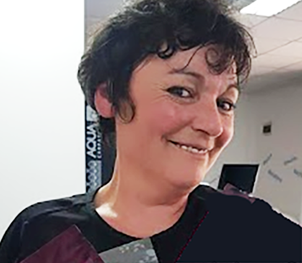 Smiling woman with short curly black hair in an indoor setting.