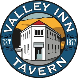 Logo for Valley Inn Tavern featuring an illustration of a white two-story building with a red roof, set against a mountainous background, with the establishment's name and founding year 1877.