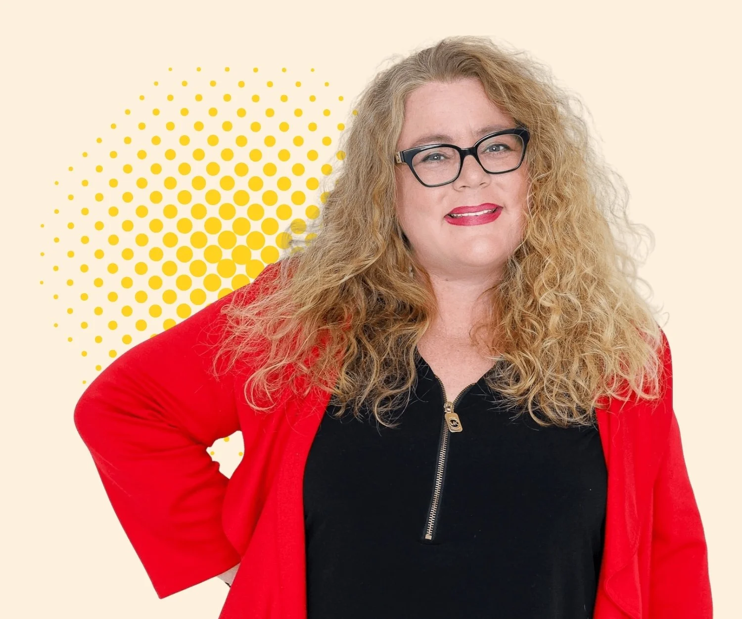A woman with blonde curly hair wearing glasses, a black zip-up top, and a red blazer, standing in front of a beige background with a yellow dotted circular pattern.