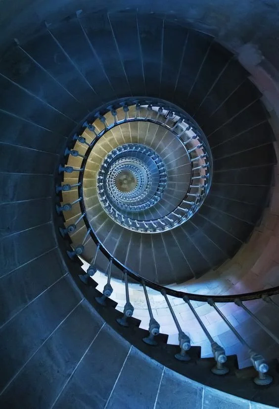 Spiral staircase viewed from above, showing the stairwell's circular pattern.