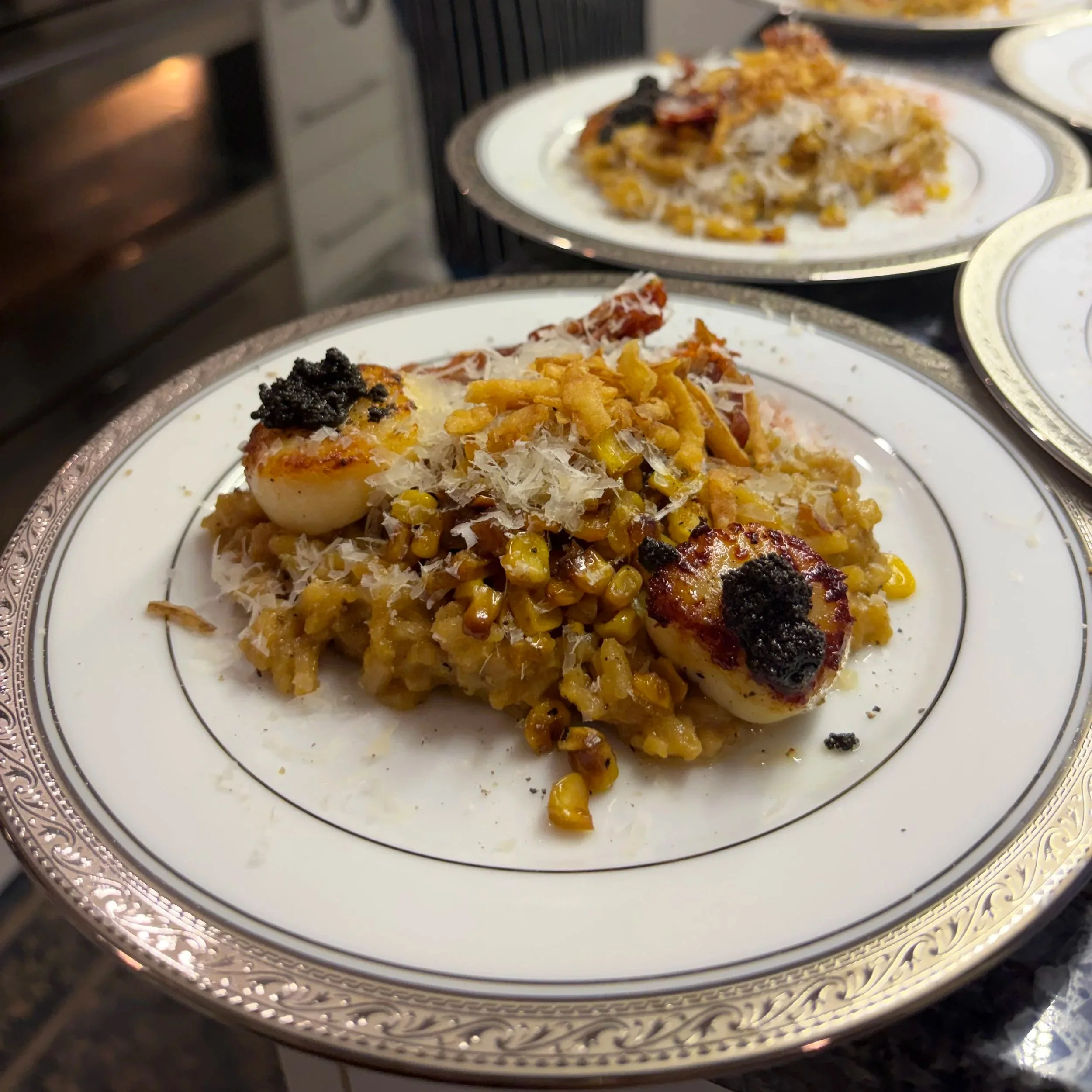 Close-up of plates with food inside an oven, featuring baked pasta, cheese, and grilled vegetables on white decorative plates with silver rims.