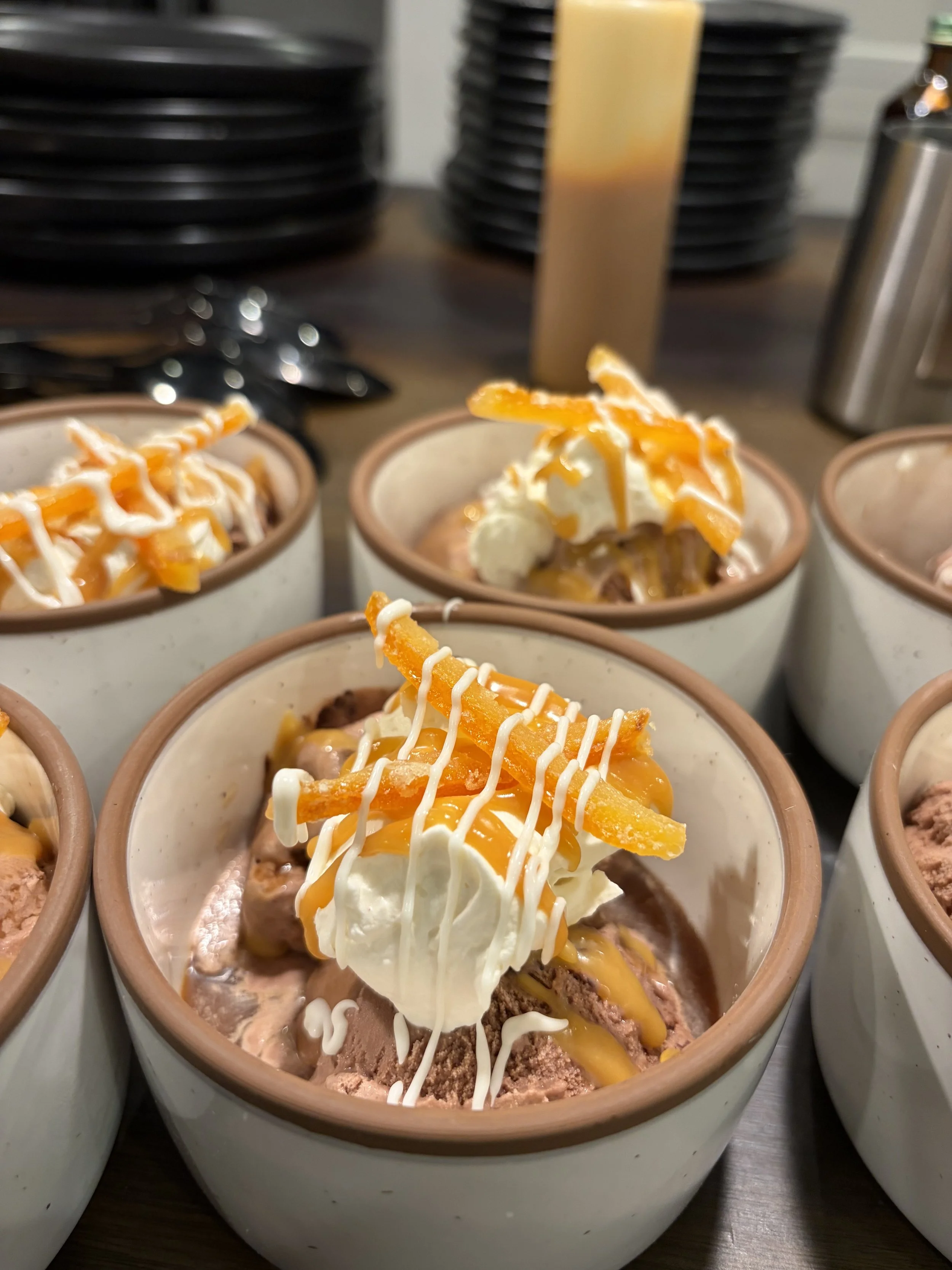 Multiple cups of tamale pie with beef, topped with sour cream, shredded cheese, and chopped peppers.