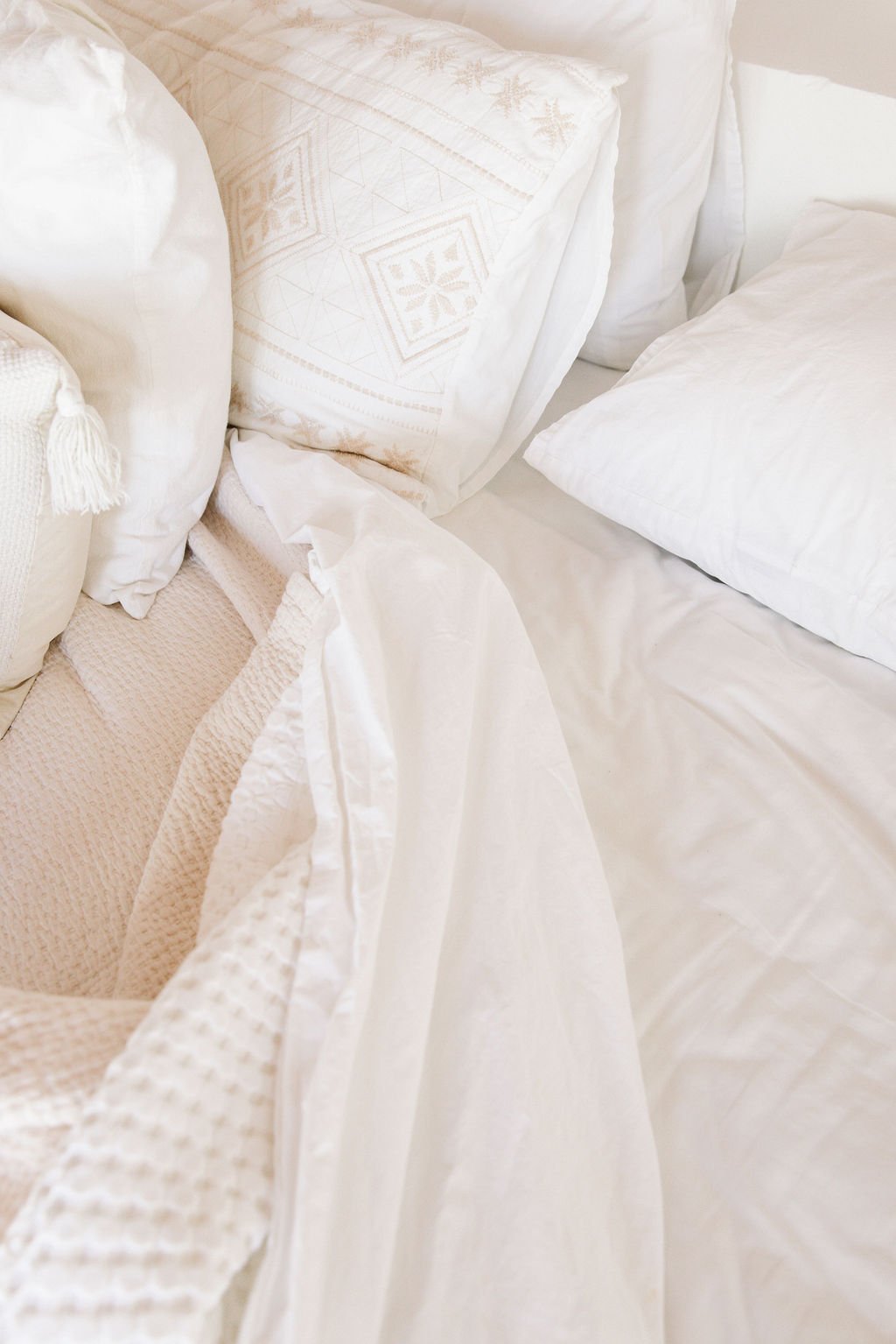 Close-up of white pillows and bedding on a bed.