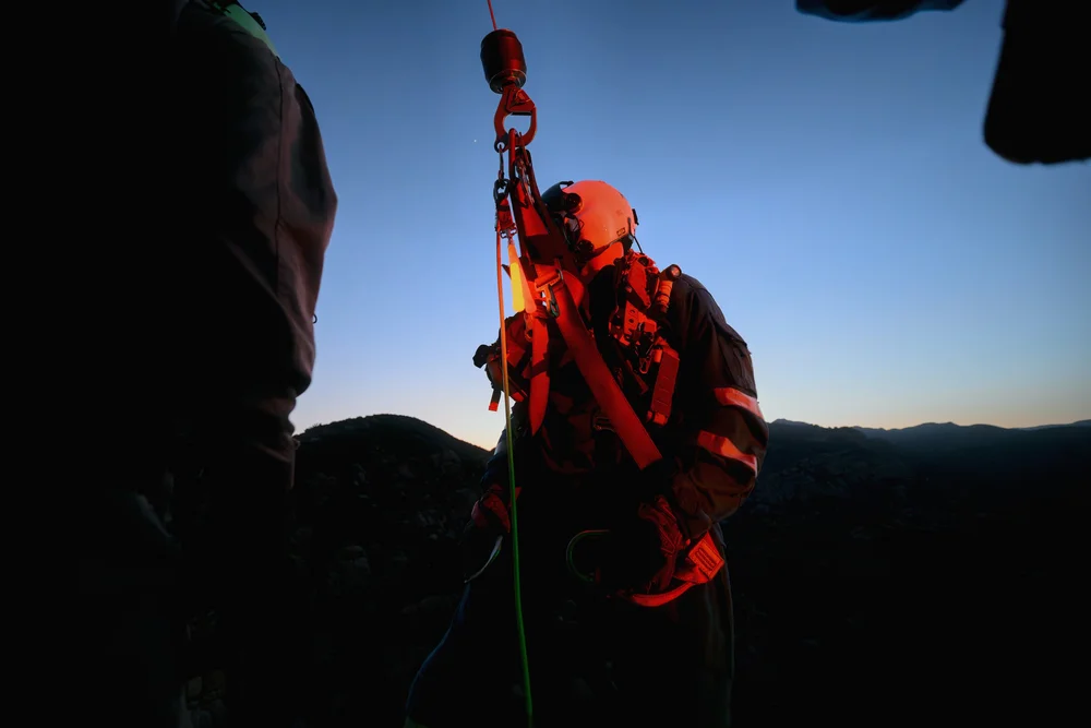 Rescuer on the hoist hook at night