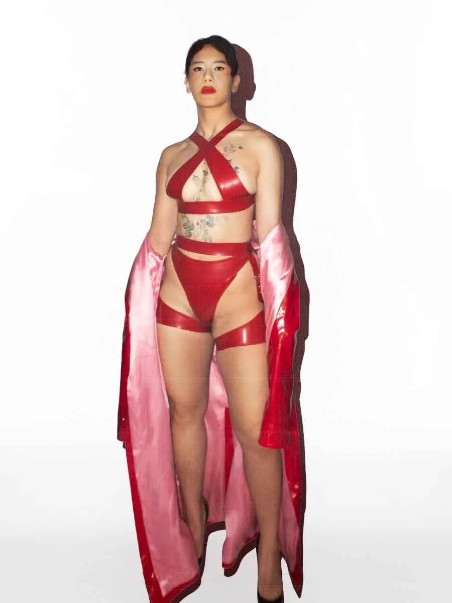 Mizu, NYC dominatrix, in red latex harness lingerie, shedding pink satin-lined robe — editorial portrait