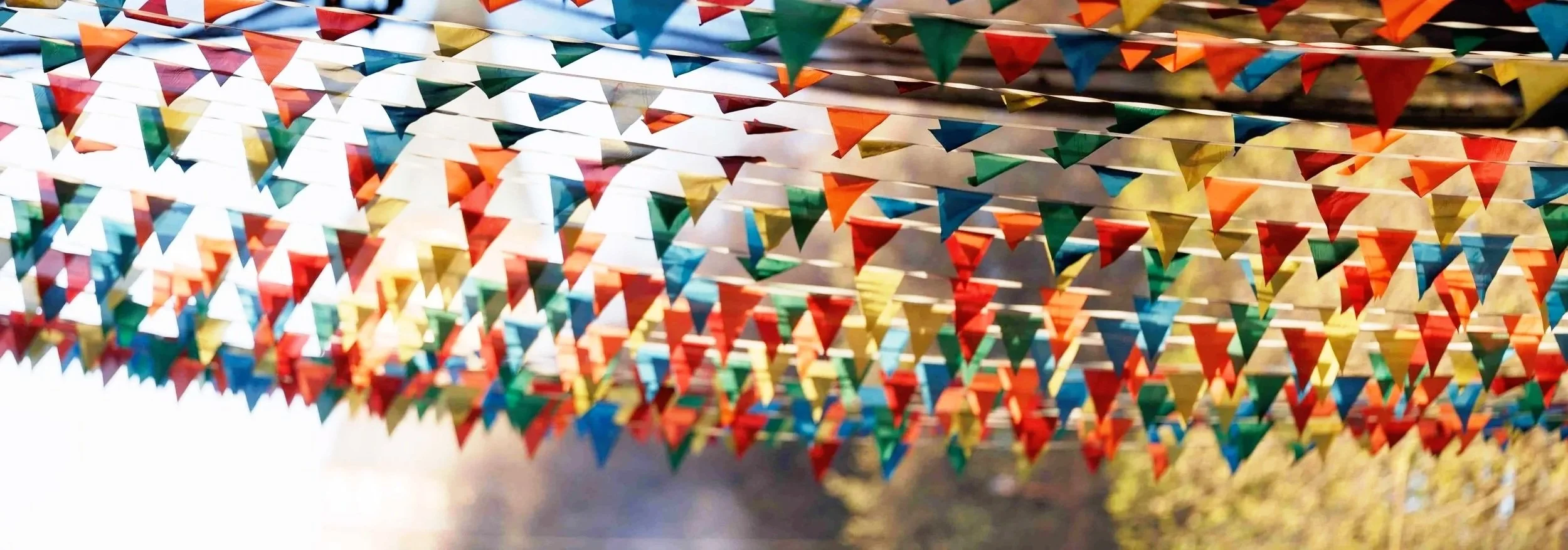 Colorful triangular flags strung overhead in an outdoor setting, creating a festive atmosphere.