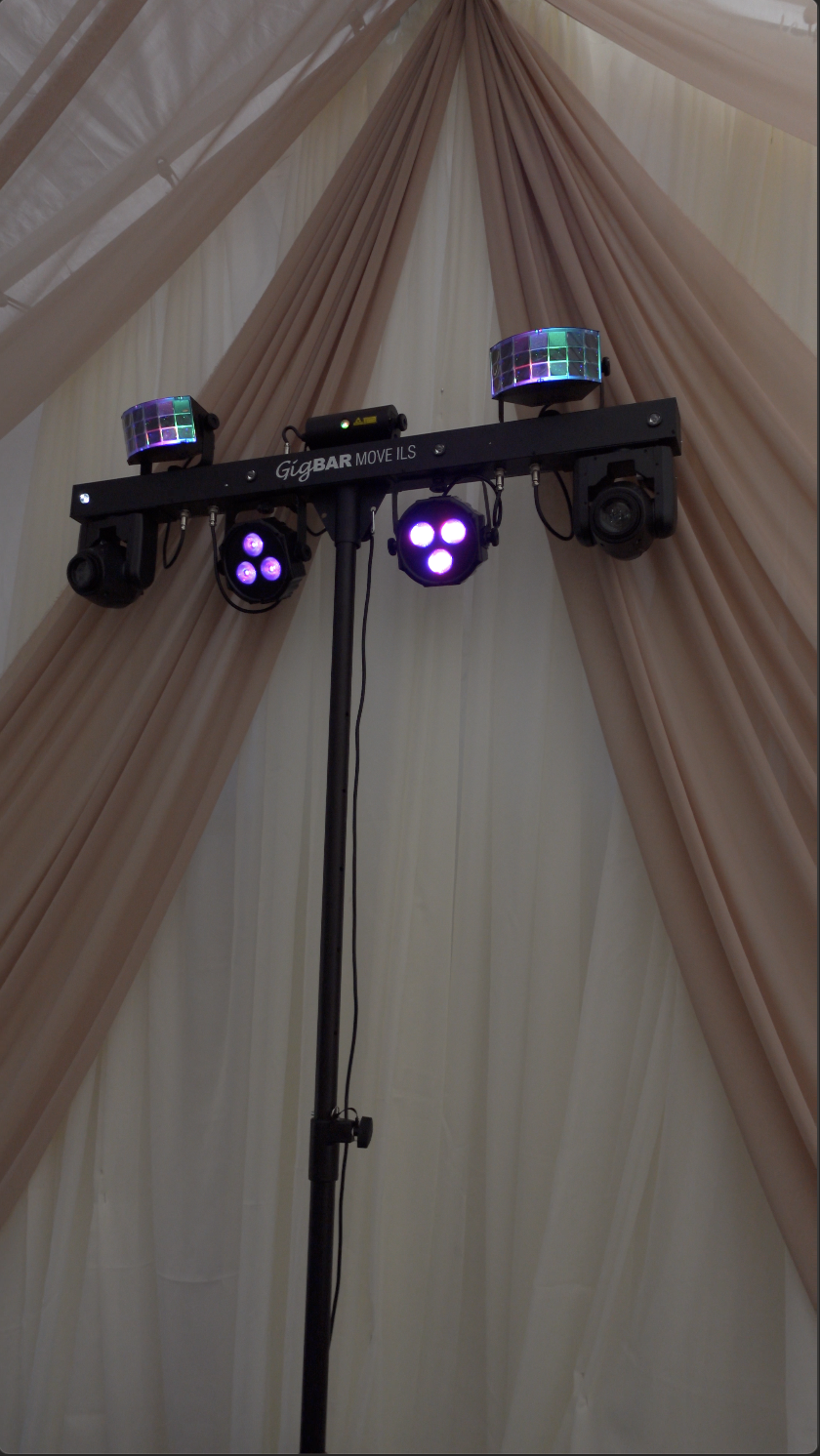 DJ lighting equipment on a stand in front of beige and pink draped curtains at an event or party.