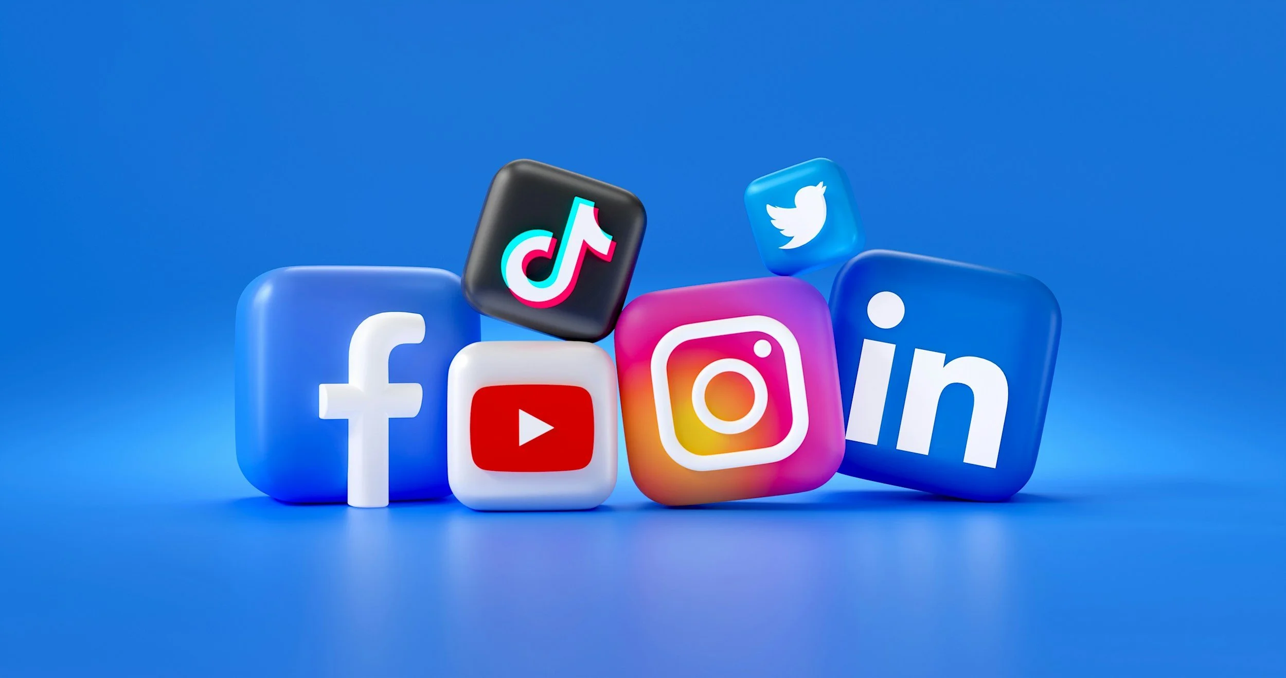 3D icons of social media platforms: Facebook, YouTube, TikTok, Instagram, Twitter, and LinkedIn on a blue background.
