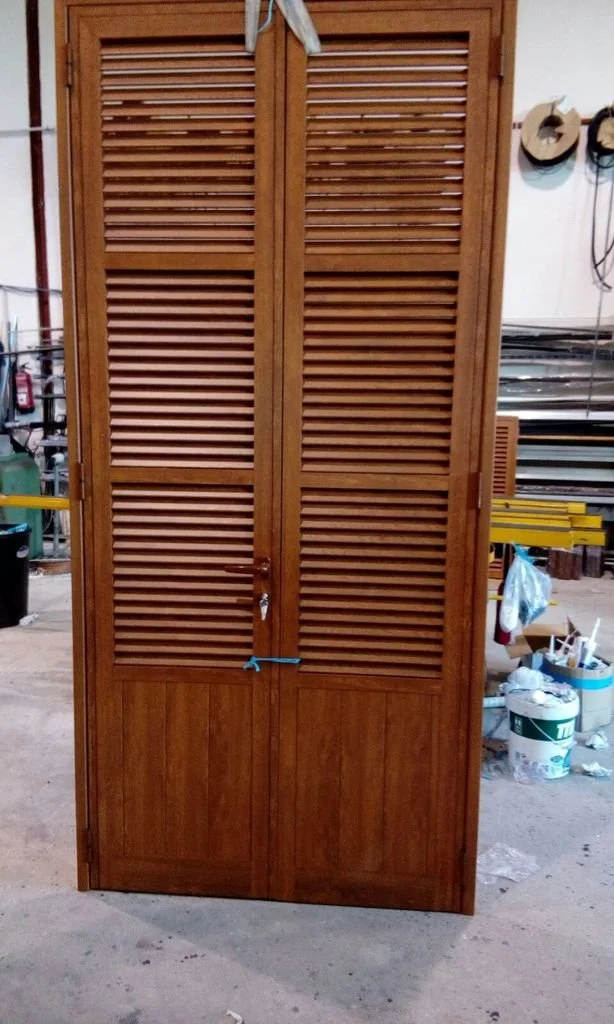 Gabinete de madera con puertas de lamas en un taller.