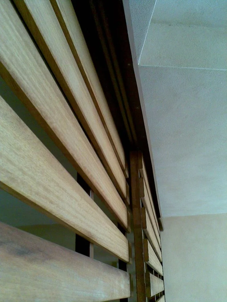 Persiana de madera en una ventana, vista desde abajo.