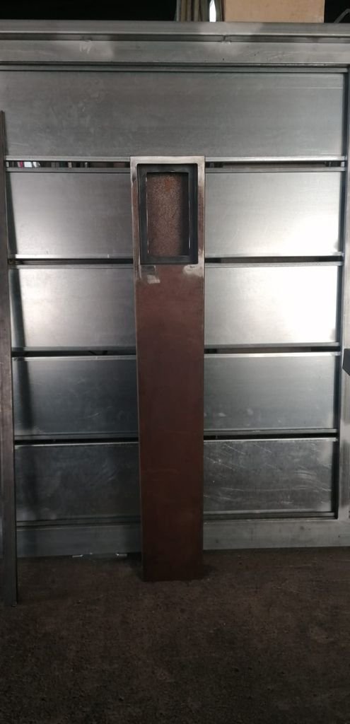 Puerta de vidrio y metal en una estructura metálica.