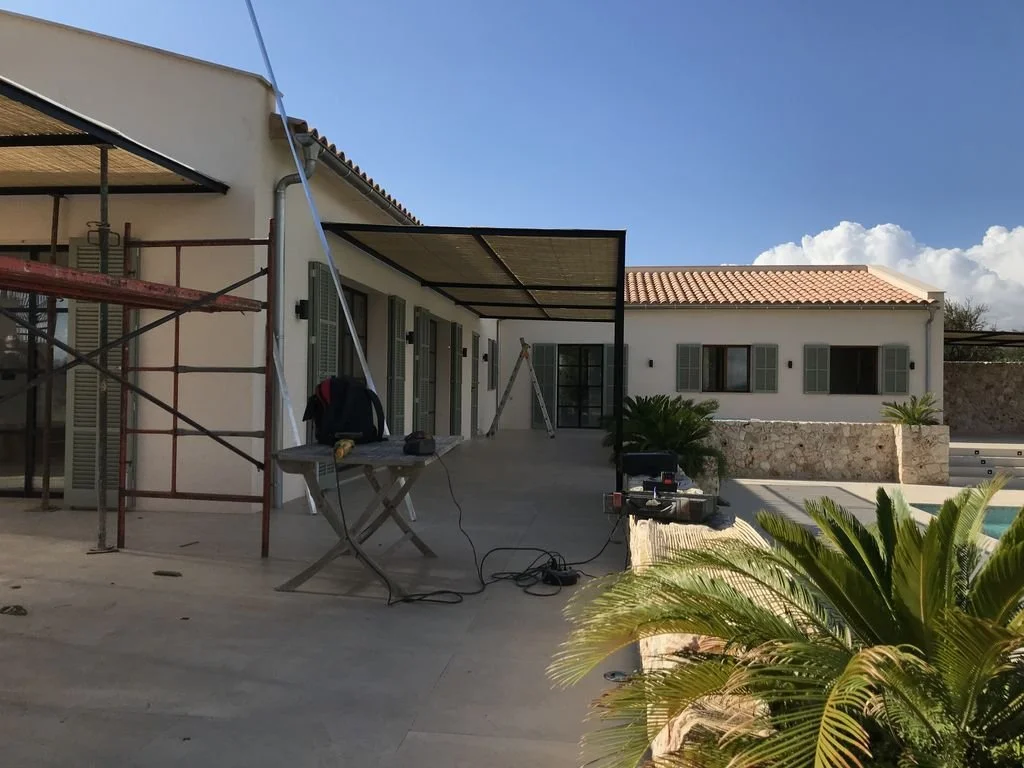 Construcción o renovación de una estructura en la terraza de una casa con varias herramientas y un couch de trabajo.