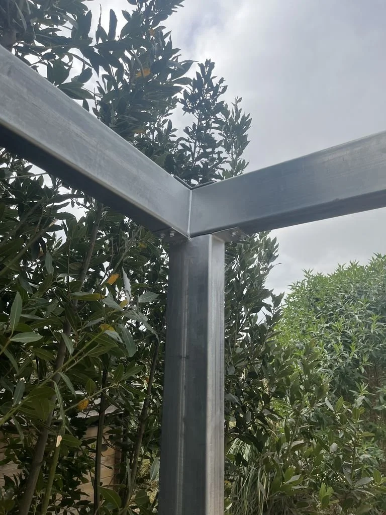 Estructura de metal en construcción en un espacio al aire libre rodeado de árboles